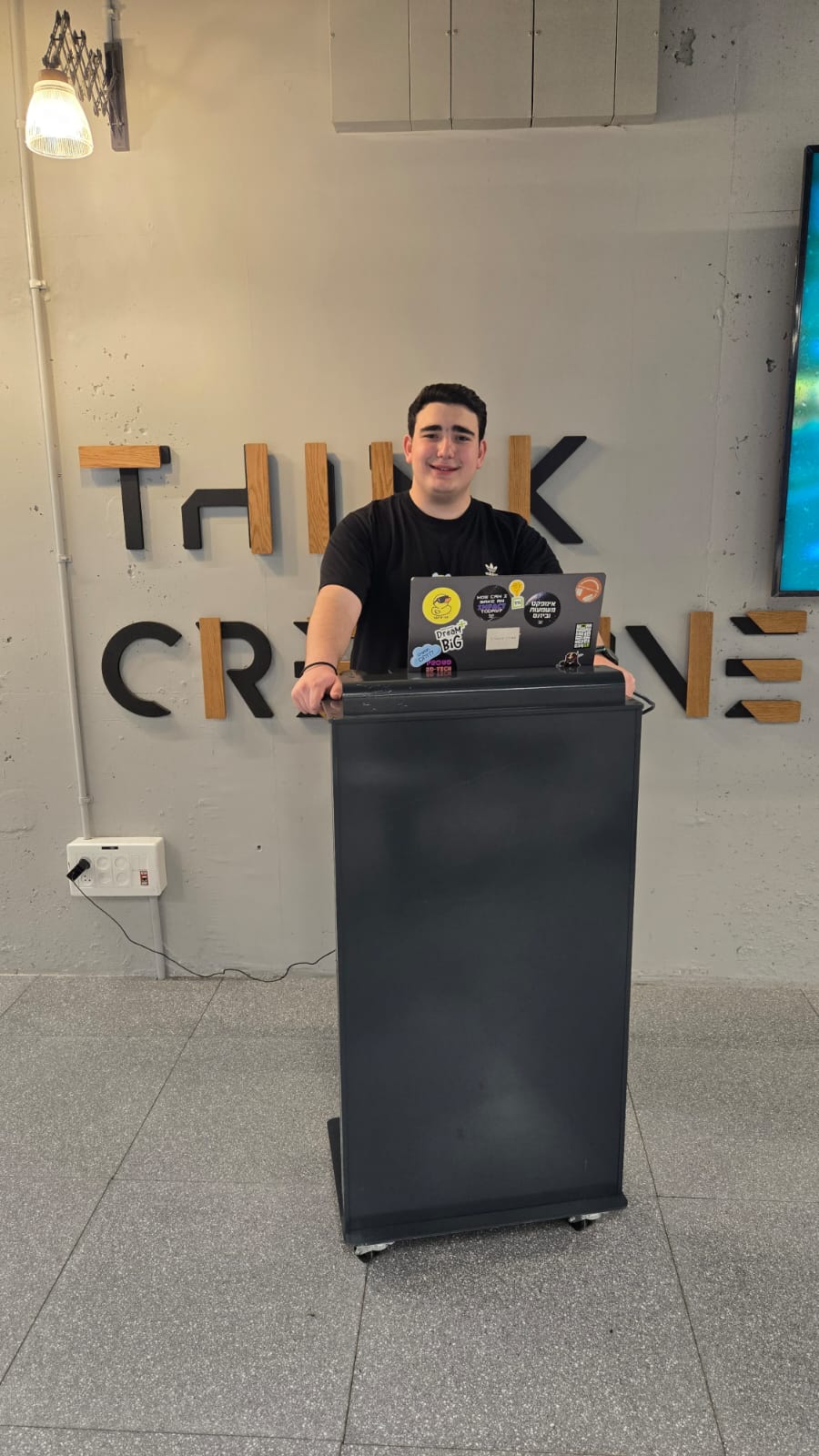Netanel standing with a computer